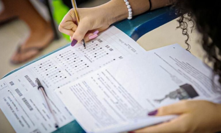 Estudante treinando com provas anteriores do Enem e simulados para testar suas habilidades para o exame.