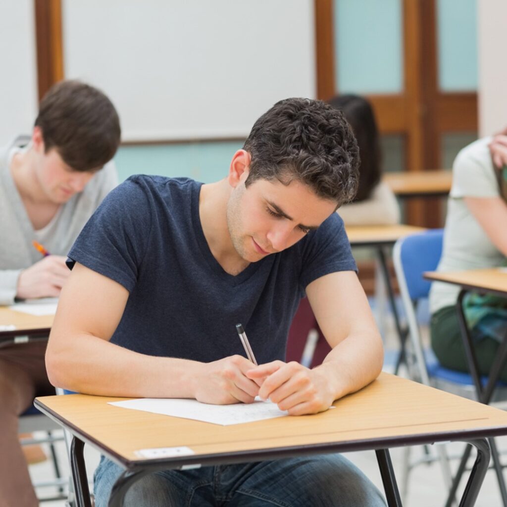 Estudante concentrado realizando a prova do vestibular Fuvest. A imagem retrata a seriedade e a dedicação exigidas durante o exame, que é um dos principais processos seletivos para ingresso na Universidade de São Paulo (USP).