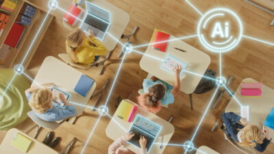 Alunos utilizando tablets e laptops conectados por IA em sala de aula, ilustrando o uso de Inteligência Artificial na Educação para aprendizado interativo.