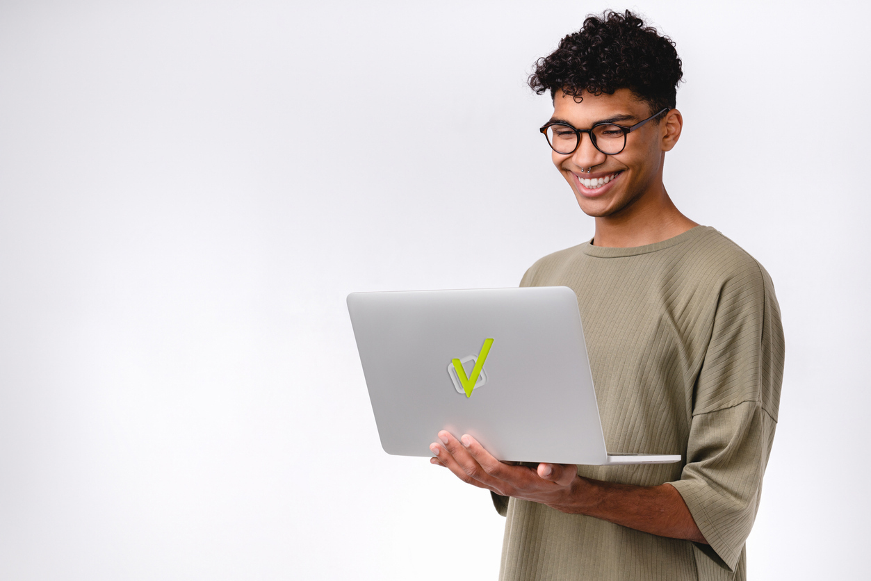 Estudante sorridente segurando notebook com logo da Estuda.com, representando como estudar online por meio de uma plataforma de estudos gratuita.