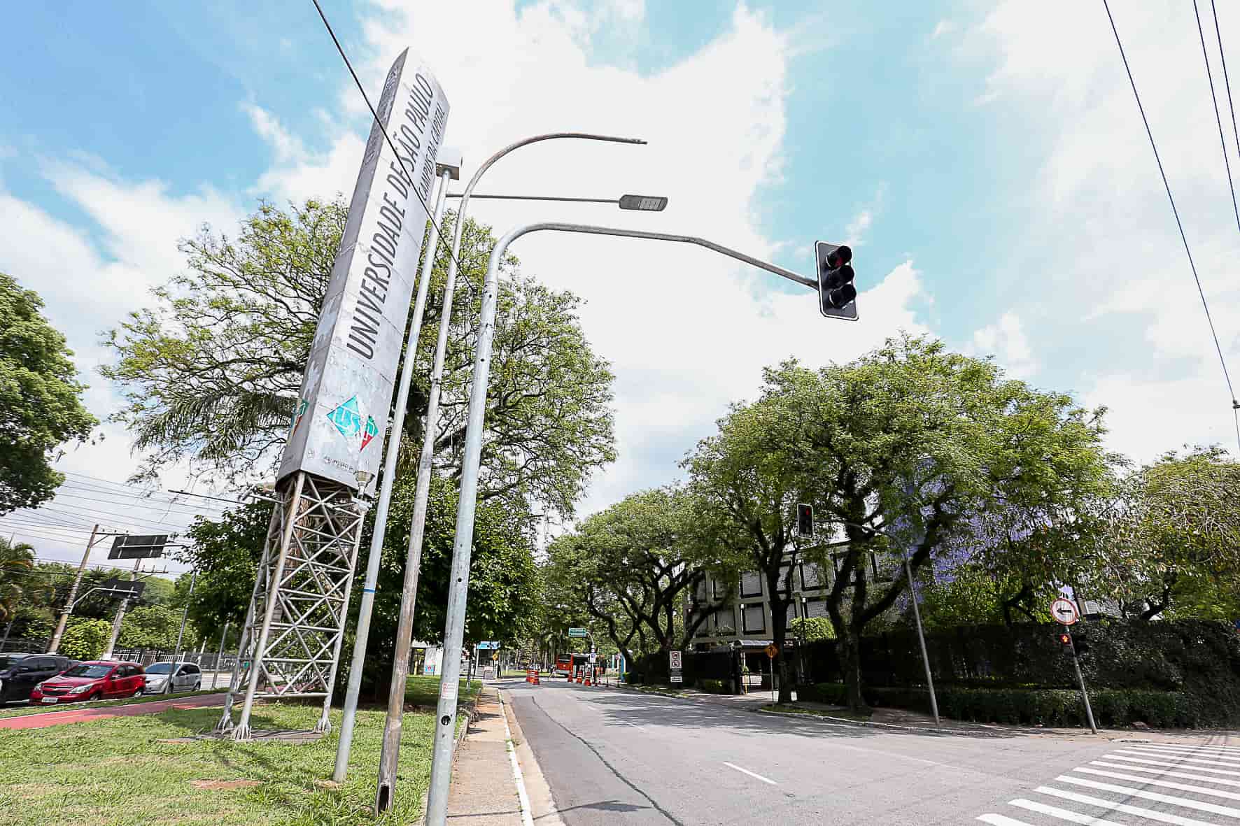 Entrada principal da Universidade de São Paulo (USP) com avenida arborizada e placa de identificação, ilustrando notícia “Vestibular Fuvest 2026 abre as inscrições”.
