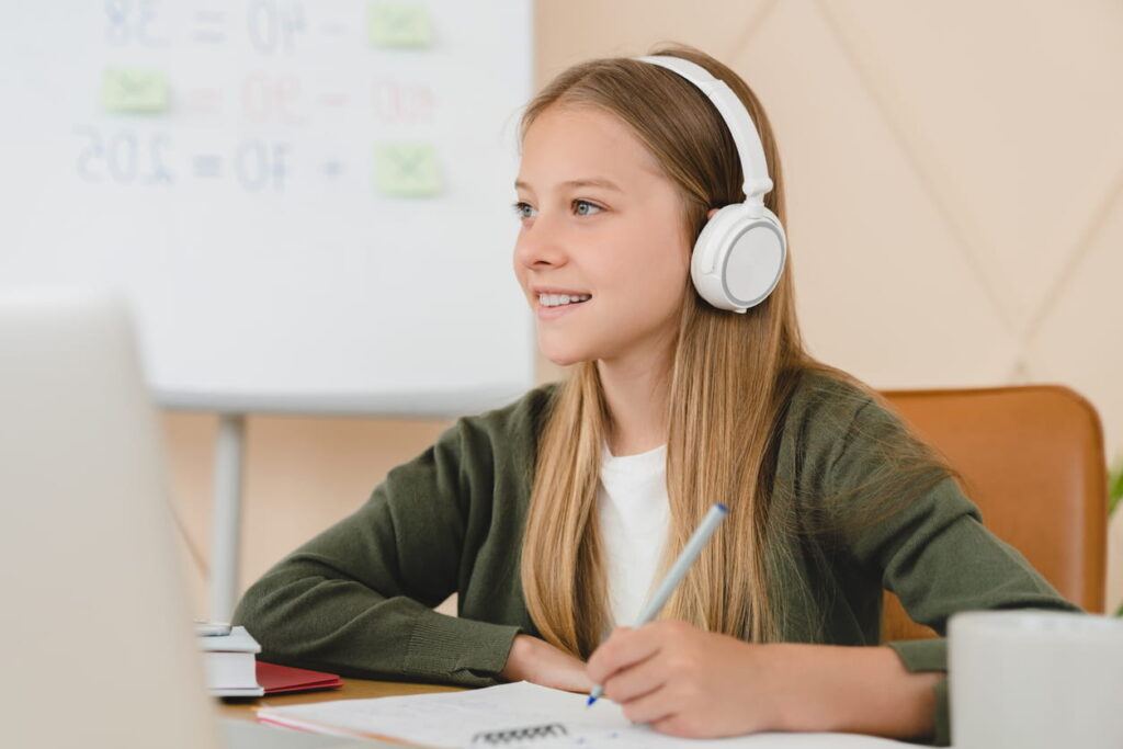 Estudante em casa usando fones de ouvido e fazendo anotações durante o simulado online, representando o Simulado gratuito Enem de Setembro 2025.