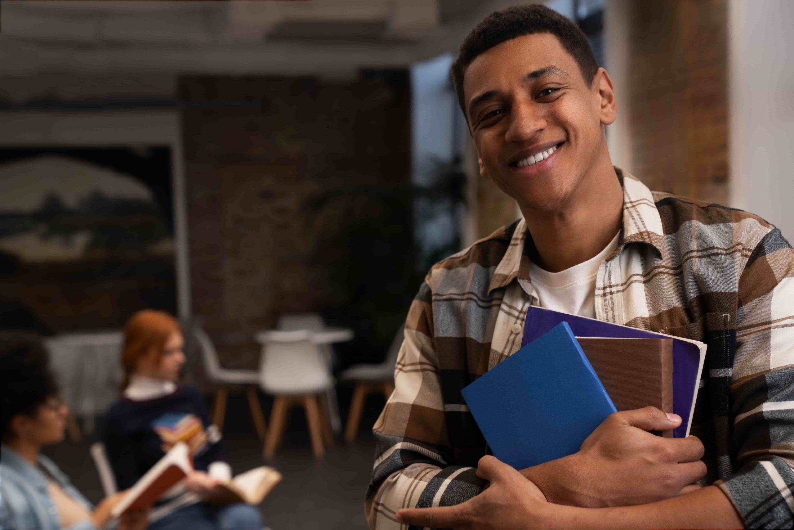 Estudante sorrindo com livros nos braços em ambiente de estudos, representando linguagens enem como estudar do zero, com foco na preparação para a prova de Linguagens, estratégias de estudo e desempenho no Enem.