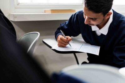 Estudante realizando prova em sala de aula, representando um simulado reta final Enem para preparação e revisão antes do exame.