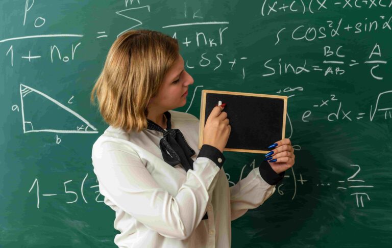 Professora explicando o Teorema de Pitágoras em sala de aula, com fórmulas matemáticas e triângulo retângulo no quadro.