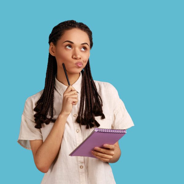 Jovem segurando caderno e caneta enquanto pensa, ilustrando dúvida comum sobre a grafia correta da expressão “Com certeza ou concerteza: qual é o correto?”