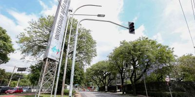 Entrada principal da Universidade de São Paulo (USP) com avenida arborizada e placa de identificação, ilustrando notícia “Vestibular Fuvest 2026 abre as inscrições”.