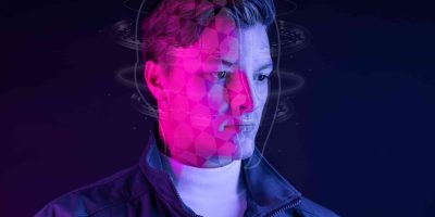 Homem com efeitos gráficos futuristas ao redor da cabeça, ilustrando processos mentais e o que estuda quem faz neurociências.